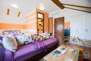 a living room with a purple couch and a table at Guest House Nena Rastoke in Slunj