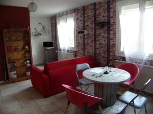 a living room with a red couch and a table at Gîte du Gecko in Saint-Christol-lès-Alès