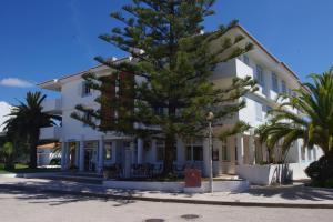 a large white building with a tree in front of it at Casa JaRoCa in Lagos