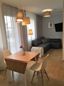 uma sala de estar com uma mesa e cadeiras e um sofá em Terrace by BestChoice - FREE Parking - Self Check-in em Graz