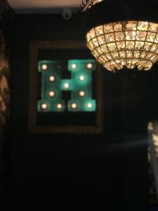 - un lustre dans une pièce dotée d'une lumière verte dans l'établissement Hôtel Le G (ex Le Genève), à Nice