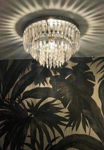 a chandelier hanging from a ceiling with a mural at Hôtel Le G (ex Le Genève) in Nice