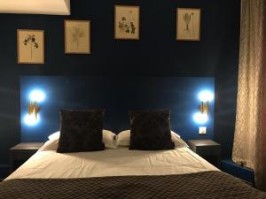a bedroom with a large bed with two night lights on it at Hôtel Le G (ex Le Genève) in Nice