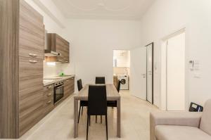 una cucina e una sala da pranzo con tavolo e sedie di S.Felice Apartments a Bologna
