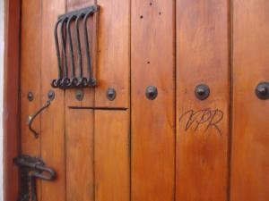a wooden door with a bunch ofieval weapons on it at Villa Pepita Real in Villa de Leyva