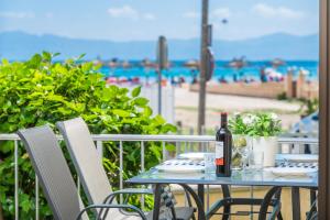 una mesa con una botella de vino en el balcón con vistas a la playa en SEASIDE HOUSE IV, en Alcudia