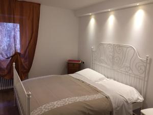 a white bed in a room with a window at Hotel du Lac Parc & Residence in Lavarone