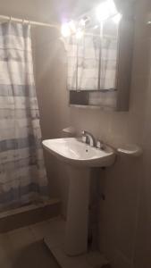 ein weißes Bad mit einem Waschbecken und einer Dusche in der Unterkunft Casa con Piscina in Chilecito