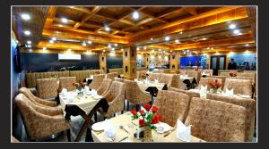 a restaurant with tables and chairs in a room at Grand Krisa Resort & SPA, Manali Experience Luxury With all Weather ACs in Every Room in Manāli