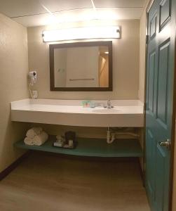 a bathroom with a sink and a mirror at The Dunes Rehoboth Beach in Dewey Beach