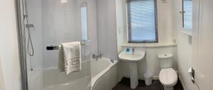 a white bathroom with a sink and a shower at Aberdeen Serviced Apartments - Bloomfield in Aberdeen