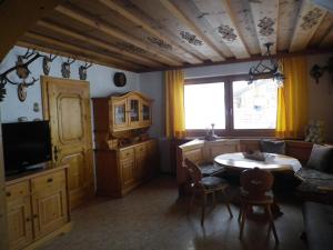 a living room with a table and a tv at Landhaus Weiss in Sankt Martin am Tennengebirge