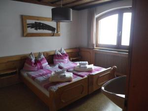 Schlafzimmer mit einem Bett mit rosa Kissen und einem Fenster in der Unterkunft Landhaus Weiss in Sankt Martin am Tennengebirge