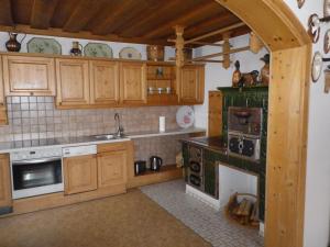 Una cocina con gabinetes de madera y un horno de estufa. en Landhaus Weiss, en Sankt Martin am Tennengebirge