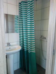a bathroom with a shower curtain and a sink at Monte Blu Holiday Apartment in Alykes