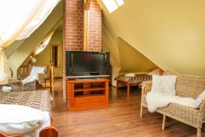 a living room with a tv on a wooden table at Willa Ostoja in Świeradów-Zdrój