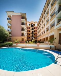 a swimming pool in front of a building at Leo Canela in Isla Canela