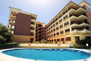 a building with a swimming pool in front of a building at Leo Canela in Isla Canela