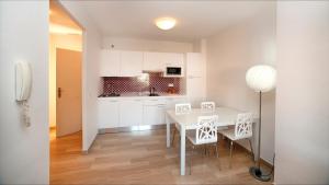 a kitchen and dining room with a white table and chairs at Leo Canela in Isla Canela