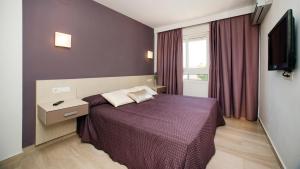 a bedroom with a purple bed and a television at Leo Canela in Isla Canela