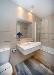 a bathroom with a sink and a toilet and a mirror at Leo Canela in Isla Canela