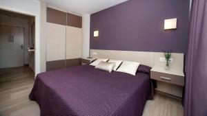 a bedroom with a purple bed with a purple wall at Leo Canela in Isla Canela