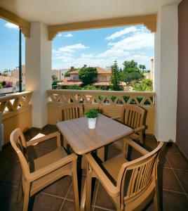 a table and chairs on a balcony with a window at Leo Canela in Isla Canela