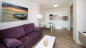 a living room with a purple couch and a kitchen at Leo Canela in Isla Canela