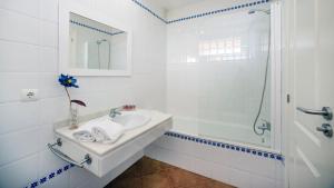 a white bathroom with a sink and a shower at Leo Canela in Isla Canela
