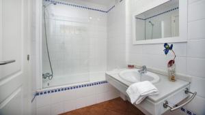 a white bathroom with a sink and a shower at Leo Canela in Isla Canela
