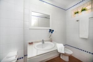 a white bathroom with a sink and a toilet at Leo Canela in Isla Canela