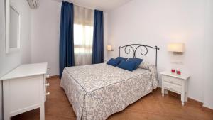 a bedroom with a bed with blue pillows and a window at Leo Canela in Isla Canela