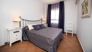 a small bedroom with a bed and a window at Leo Canela in Isla Canela