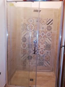 a shower with a glass door with a tiled wall at APPARTAMENTO IN CENTRO in Marsala