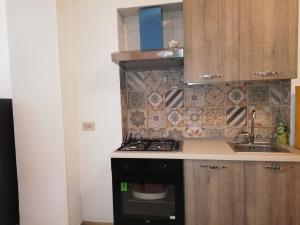 a small kitchen with a stove and a sink at APPARTAMENTO IN CENTRO in Marsala