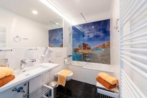 a white bathroom with a sink and a tub at Skyflats Vienna Ring View in Vienna