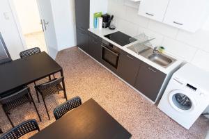 a kitchen with a table and a sink and a washing machine at AVR Apartment Geestemunde 2 in Bremerhaven