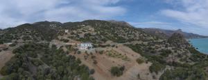 an island with a house on top of a mountain at Skouros Villa in Kastrí