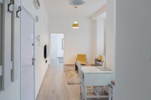 un corridoio con una stanza con pareti bianche e un tavolo di Jumi a Belgrado