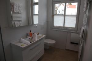 a bathroom with a sink and a toilet and a mirror at Schützen Hotel & ConceptStore in Meersburg