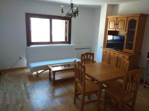a living room with a table and a couch at APARTAMENTOS LÁZARO-Calle Iglesia 8 - 1º C in Escarrilla