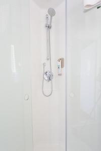 y baño con ducha y puerta de cristal. en Ibis Elche, en Elche