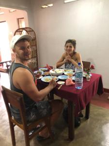 een man en een vrouw zitten aan een tafel en eten bij Surf reef guest house in Mirissa +35 foto's