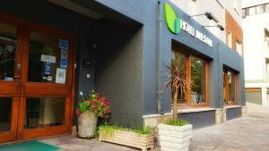 una fachada de un edificio con flores delante de él en Hotel Meson, en Pinamar