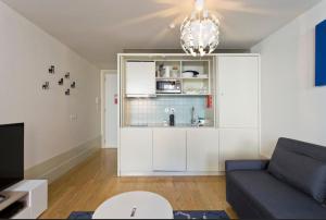 ein Wohnzimmer mit einem Sofa und einer Küche in der Unterkunft Vitoria Studio Residence II - Downtown in Porto