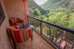 a balcony with two chairs and a view of the mountains at Dar Ikalimo Ourika in Aghbalou