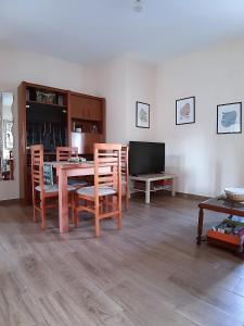 a dining room with a table and chairs and a television at Modern Family Flat Málaga in Málaga