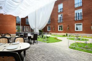 Un patio con mesas y sillas y un edificio. en Hotel Imperial Wellness & SPA, en Obninsk