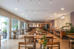a restaurant with wooden tables and chairs and windows at Hotel Serra de Jundiaí in Jundiaí