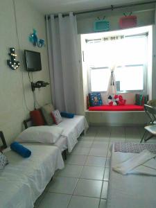 um quarto de hotel com três camas e uma janela em Apartamento Studio ao Lado da Praia com Wi-Fi e TV Smart em Santos